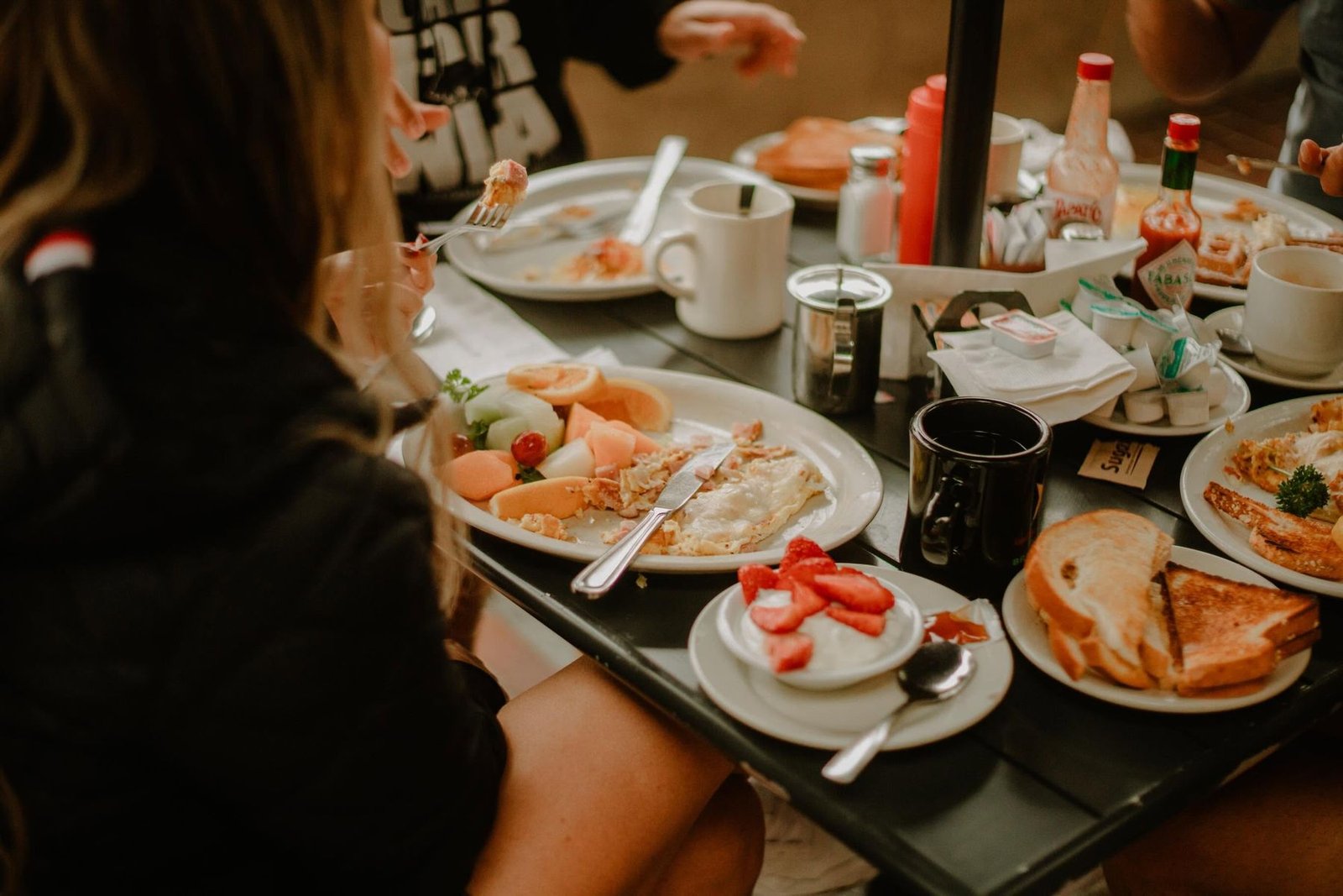 A shared brunch table full of plates